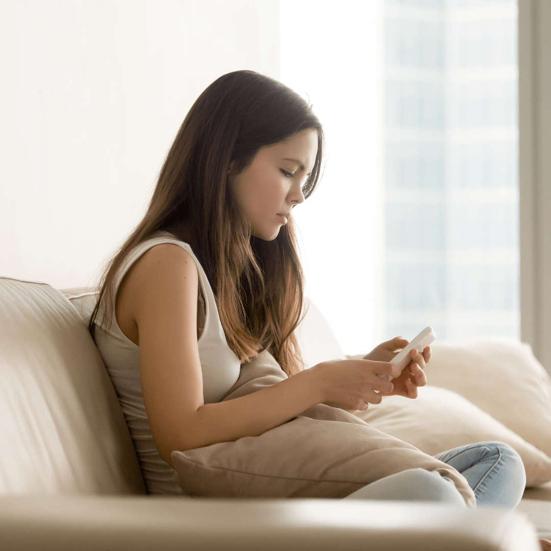 Teenage girl with eating disorder looking at her phone