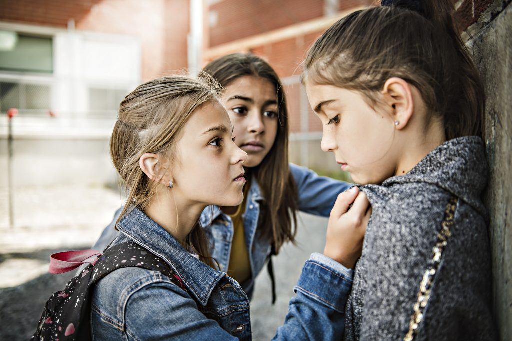 Disruptive behavior in schools exhibited by teenage girl in hallway.